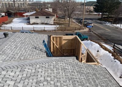 Aerial view of a framed second-story addition above a garage roof with street view