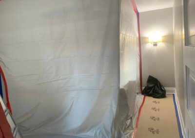 Interior room sealed with plastic sheeting and floor protection during construction