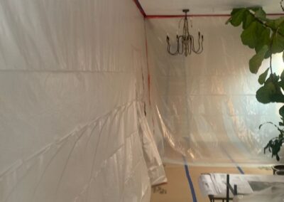 Room interior protected with plastic wall sheeting and floor covering during construction