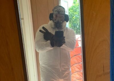 Shane Marberry wearing plastic paint cover, mask, safety goggles, and gloves.
