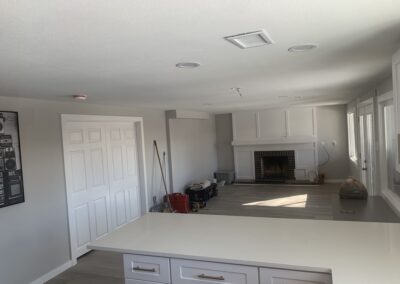 Finished basement living area with white paneled fireplace surround and brick firebox
