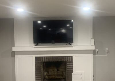 Close-up of white fireplace mantel with brick surround and mounted TV