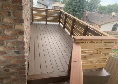 Covered balcony with white painted balusters and wood decking