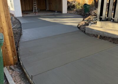 Detached garage with new concrete driveway leading to the open bay