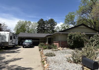 Ranch-style house exterior with driveway and desert landscaping before addition