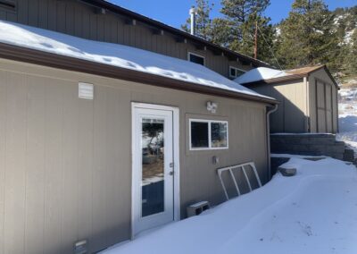 Close-up of mountain home addition exterior with new siding, door, and window