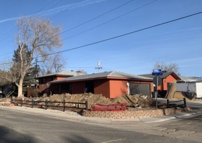 Ranch house exterior with dirt piles in the yard before siding remodel